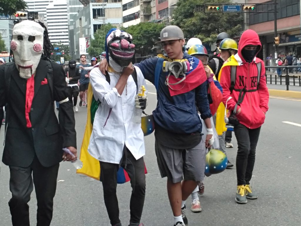 Jóvenes con máscaras antigás durante una protesta en Caracas. Foto: Manuel Rueda/Agência Pública.
