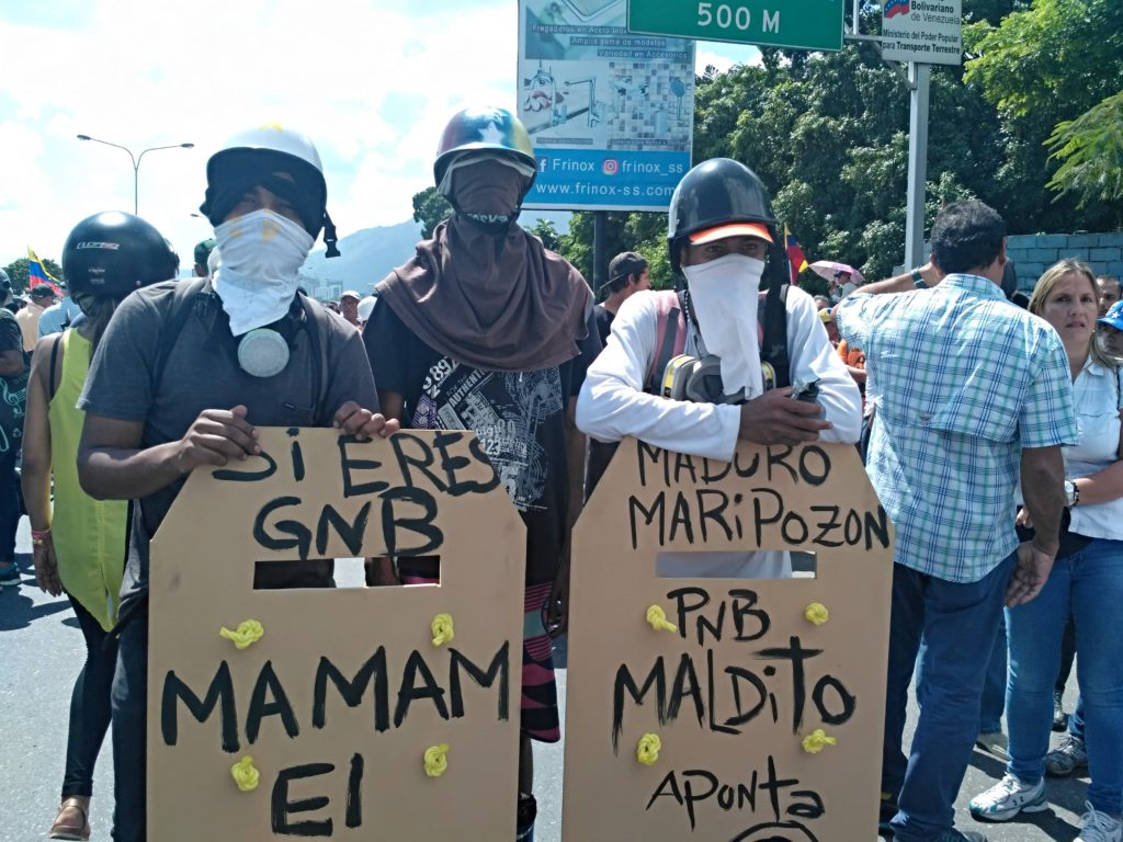 Manifestantes con escudos tallados en madera. Foto: Manuel Rueda/Agência Pública.