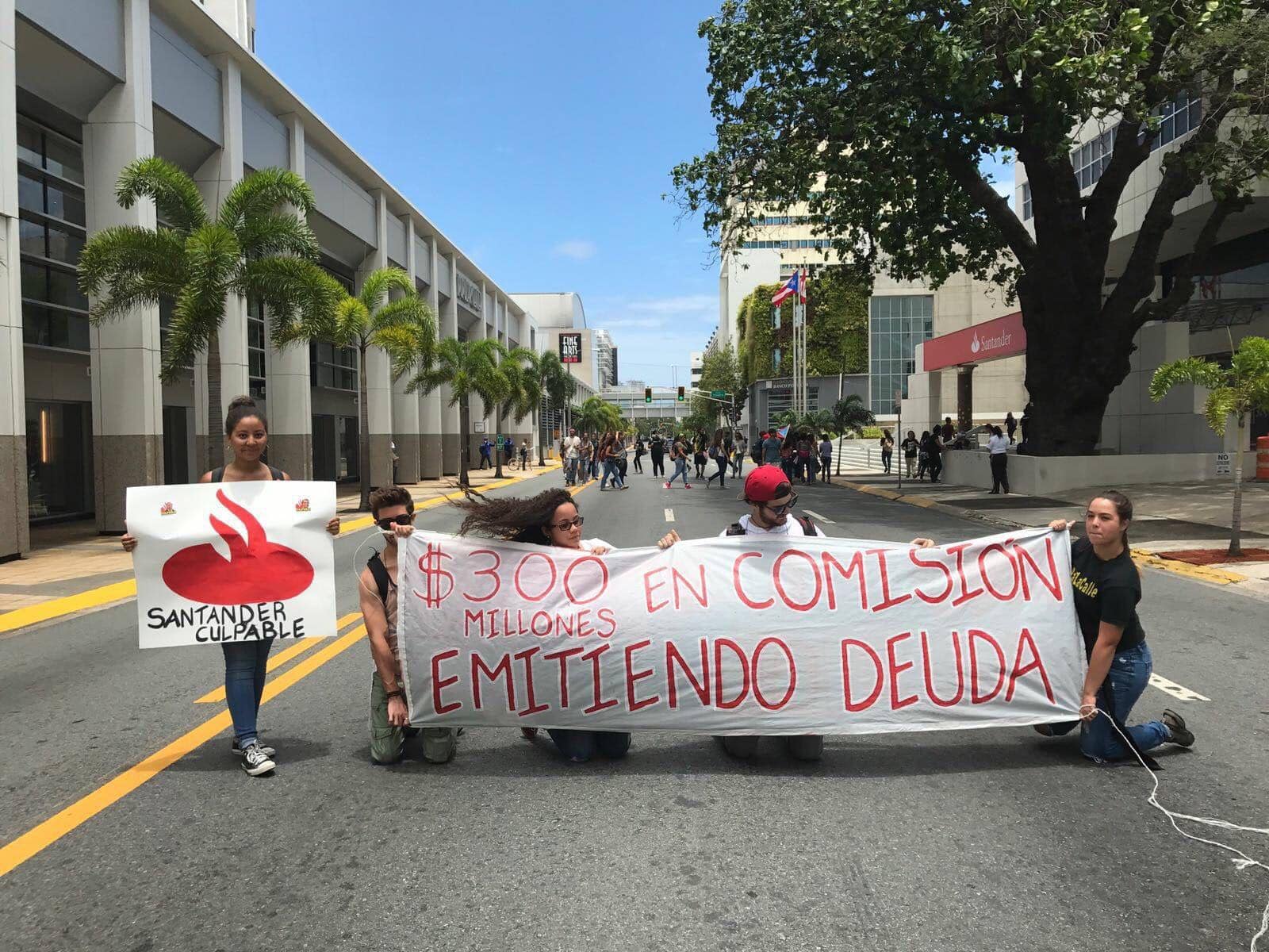 Un grupo de estudiantes sostiene una pancarta contra el Banco Santander en San Juan, Puerto Rico. Foto: David Galarza.
