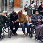 Dos señoras dependientes, acompañadas de sus cuidadoras, en una plaza del centro de Madrid. FERNANDO SÁNCHEZ ECONOMÍA FEMINISTA