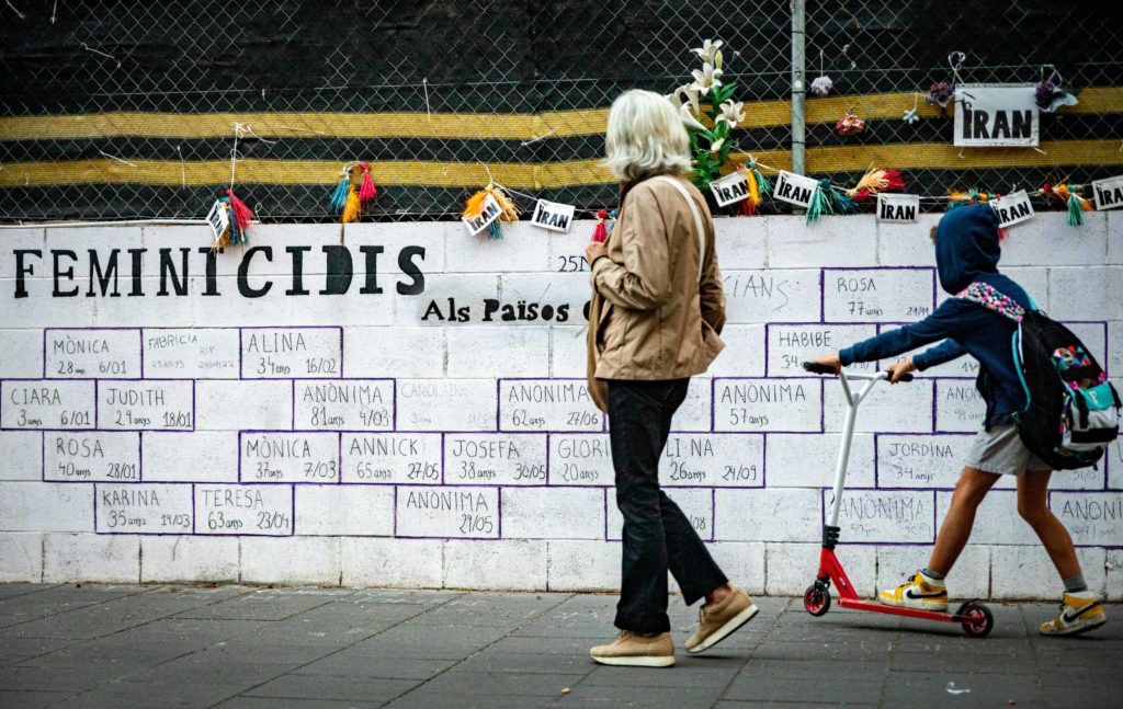 Una mujer y un niño observan un homenaje a las víctimas de crímenes machistas.