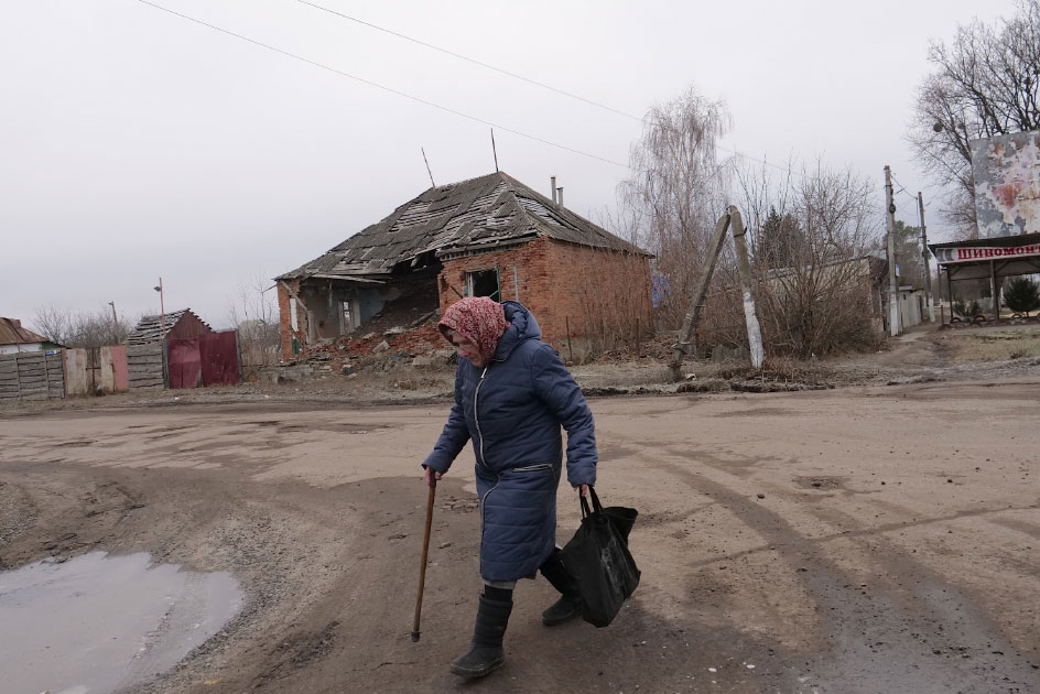 Un anciana sale a por comida en la aldea arrasada de Tsupyvka. Foto: Unai Aranzadi.